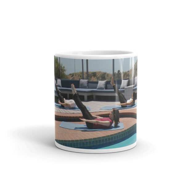 white glossy mug with people doing a pilates pose outdoors
