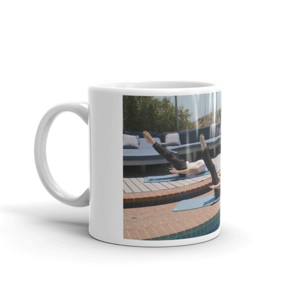 white glossy mug with people doing a pilates pose outdoors