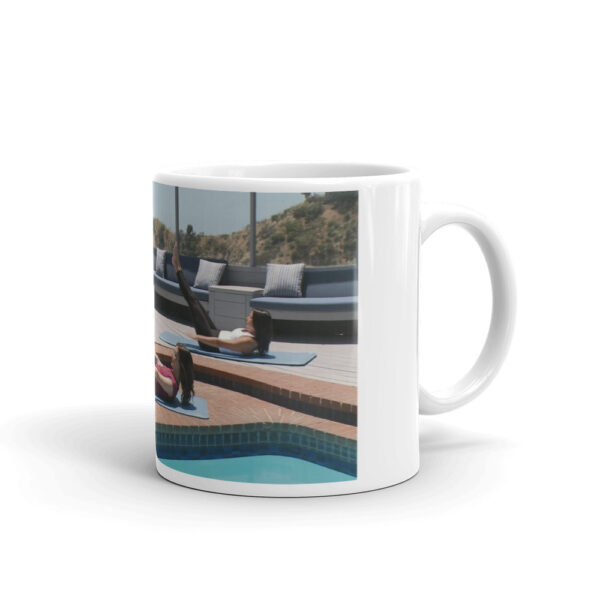 white glossy mug with people doing a pilates pose outdoors